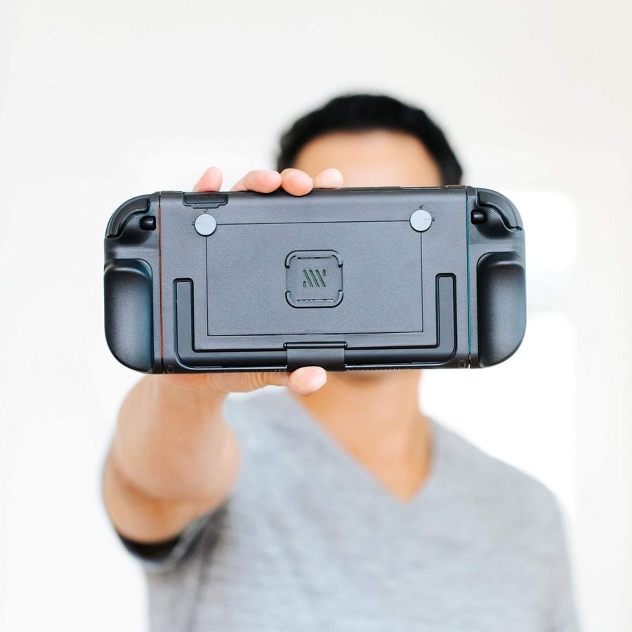 Player holding up a Switch 2 in the Mechanism Basecase toward the camera