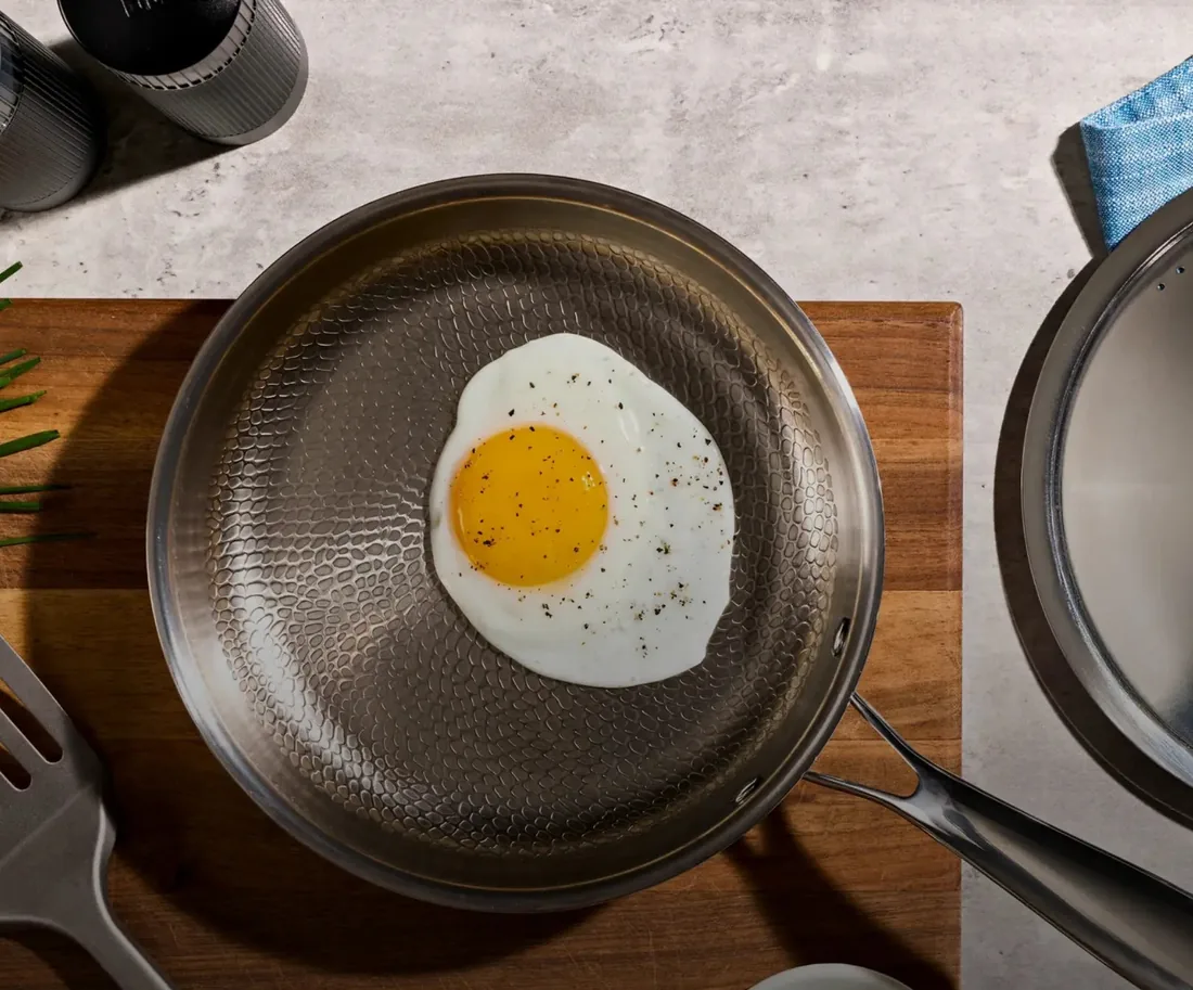 A fried egg cooking in the hammered surface of a Siraat titanium pan