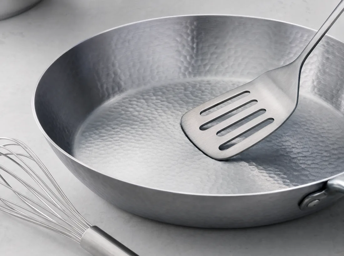 Metal spatula and whisk used on a titanium pan that shows no scratches
